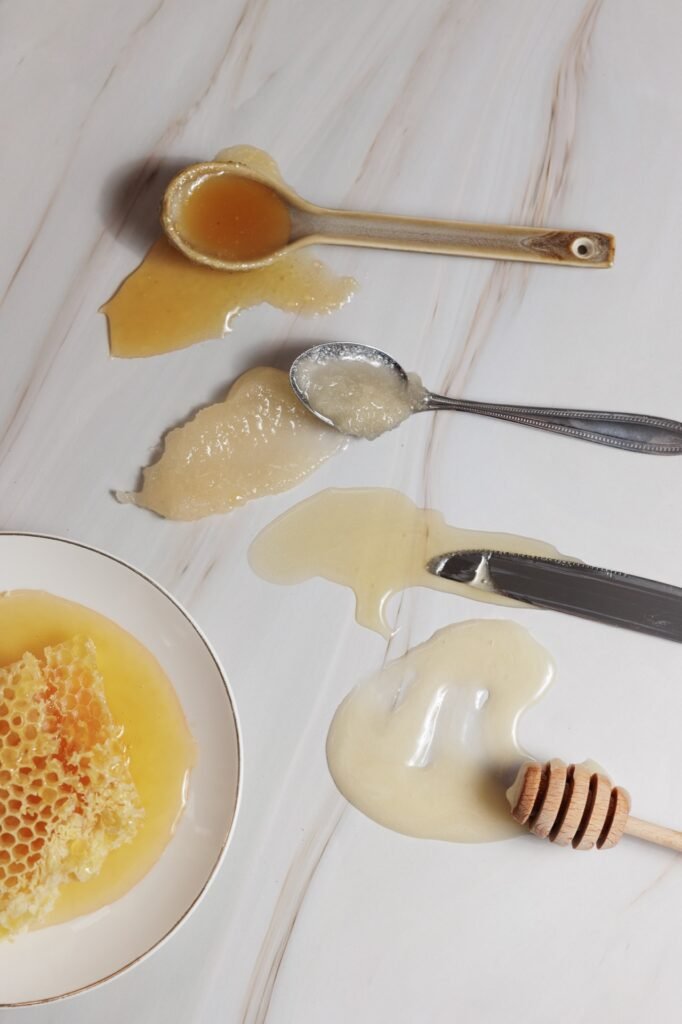 Łyżki na stole oblane miodem